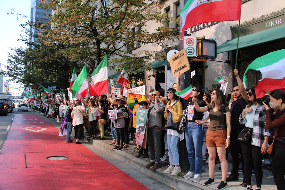 Crowd protesting in Vancouver, BC, holding flags and signs advocating freedom.
