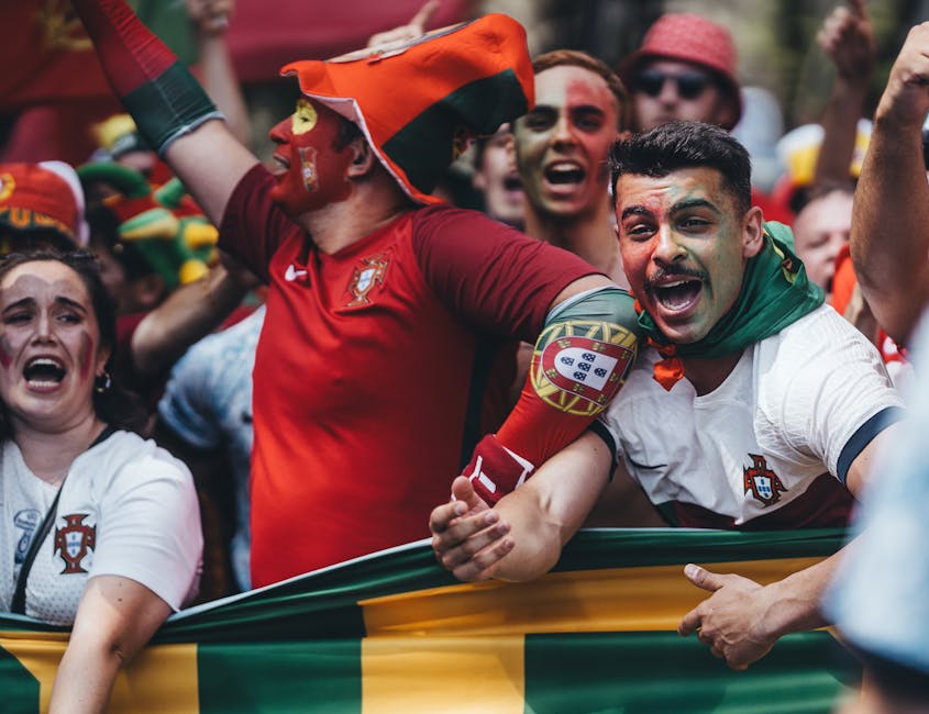 Passionate Portuguese soccer fans celebrating outdoors with flags and face paint.